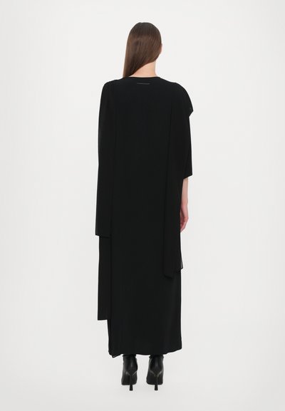 Long black dress with a flowy silhouette, featuring short sleeves, a round neckline, and layered fabric detailing at the back.