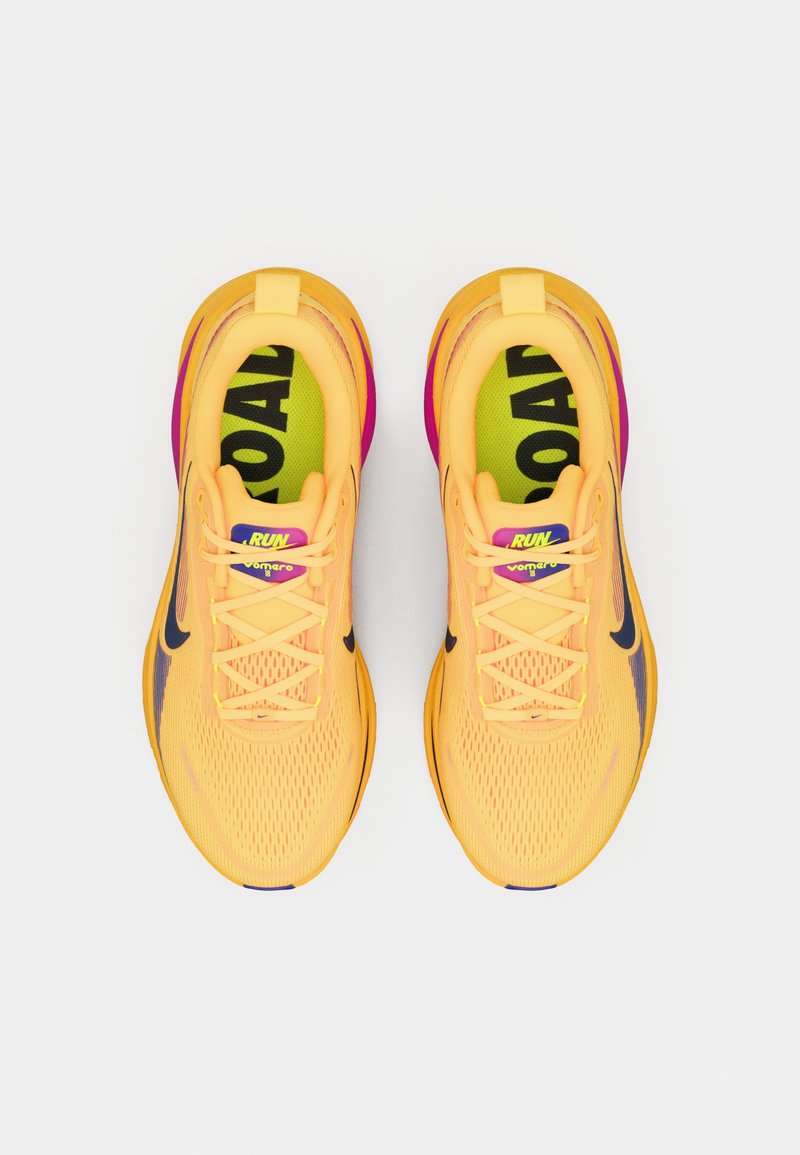 Zapatillas de correr amarillas con parte superior de malla, detalles en púrpura y logo negro. Suela acolchada con texto destacado "RUN" y "ROAD" en las plantillas.