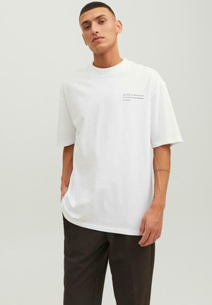 Hvid kortærmet t-shirt i bomuld med en afslappet pasform, prydet med minimal sort tekst på den øverste venstre side. Glat tekstur, klassisk design.