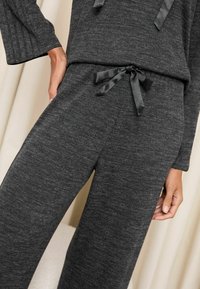 Charcoal grå loungewear sæt med ribbet tekstur, der har en justerbar talje med satinbånd og afslappede bukser med brede ben.