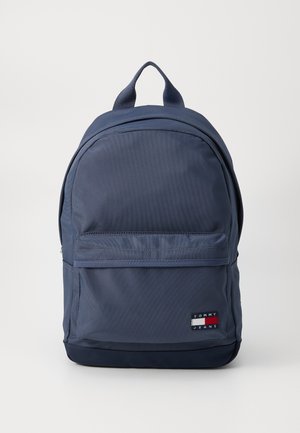 Mochila azul marinho feita de tecido durável, com um bolso frontal com zíper, alças de ombro ajustáveis e uma alça de transporte superior.