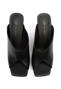 Mules en cuir noir à bout ouvert au design épuré, dotés d'un bout carré et d'un détail découpé à l'avant. Doublure intérieure douce.