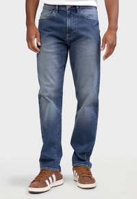 Σκούρο μπλε τζιν με κλασικό σχέδιο, που διαθέτει ίσια γραμμή, ξεβαμμένες λεπτομέρειες, πέντε τσέπες και ραμμένες λεπτομέρειες.