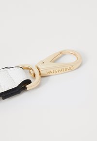 White textured strap with black edging and a gold metal clasp featuring "VALENTINO" engraved on it.