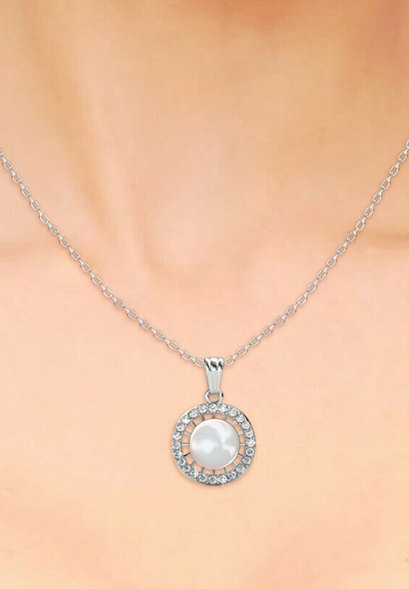Collana d'argento con un pendente rotondo che presenta una perla bianca centrale circondata da una cornice circolare di gemme scintillanti.