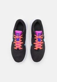 Chaussures de sport noires avec tige en mesh, lacets roses contrastants et accents bleus. Semelles blanches, bout rond et languette rembourrée pour le confort.