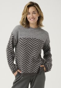 Grauer Strickpullover mit einem Chevron-Muster in Dunkelgrau und Hellgrau, Rundhalsausschnitt und langen Ärmeln. Lockere Passform mit gerippten Akzenten.