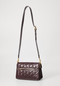 Quilted burgundy leather handbag with a detachable shoulder strap and gold-tone hardware, featuring a front zip pocket.