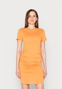 Vestido curto de algodão laranja com mangas curtas, apresentando um design ajustado com franzidos nas laterais, criando uma silhueta elegante. Textura suave.