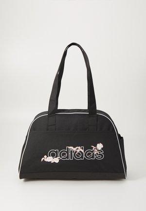 Bolsa de tela negra con acentos en blanco, que presenta un destacado logo de "adidas" y bordado floral en rosa. Dos asas para llevar.