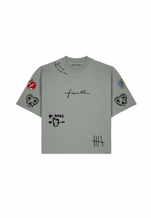 Maglietta grigia con stampe grafiche nere e rosse che includono la parola "faith," cuori, labbra, "Mi Amor," e motivo sole e luna sulle maniche.