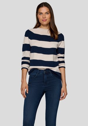 Gestreifter Pullover mit horizontalen Streifen in Marineblau und Beige. Strickmaterial, Rundhalsausschnitt, langärmlig mit hochgeschobenen Ärmeln, kombiniert mit dunkler Jeans.