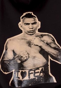 Black t-shirt featuring a large black-and-white graphic of a muscular boxer with a mohawk, wearing a belt that reads "I ❤️ FEA."