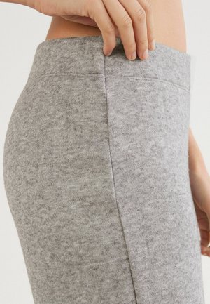 Jupe grise taille haute en tissu doux et texturé ; caractérisée par une finition lisse et des coutures subtiles le long des côtés.
