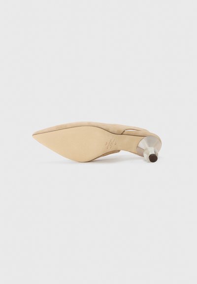 Beige suede high-heeled shoe with pointed toe, minimalist design, and a metallic-accented heel. Smooth texture, sleek silhouette.
