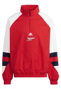 Chaqueta de pulóver roja y blanca con media cremallera, que presenta un dobladillo acanalado, detalles en azul marino y un logo bordado en el pecho.