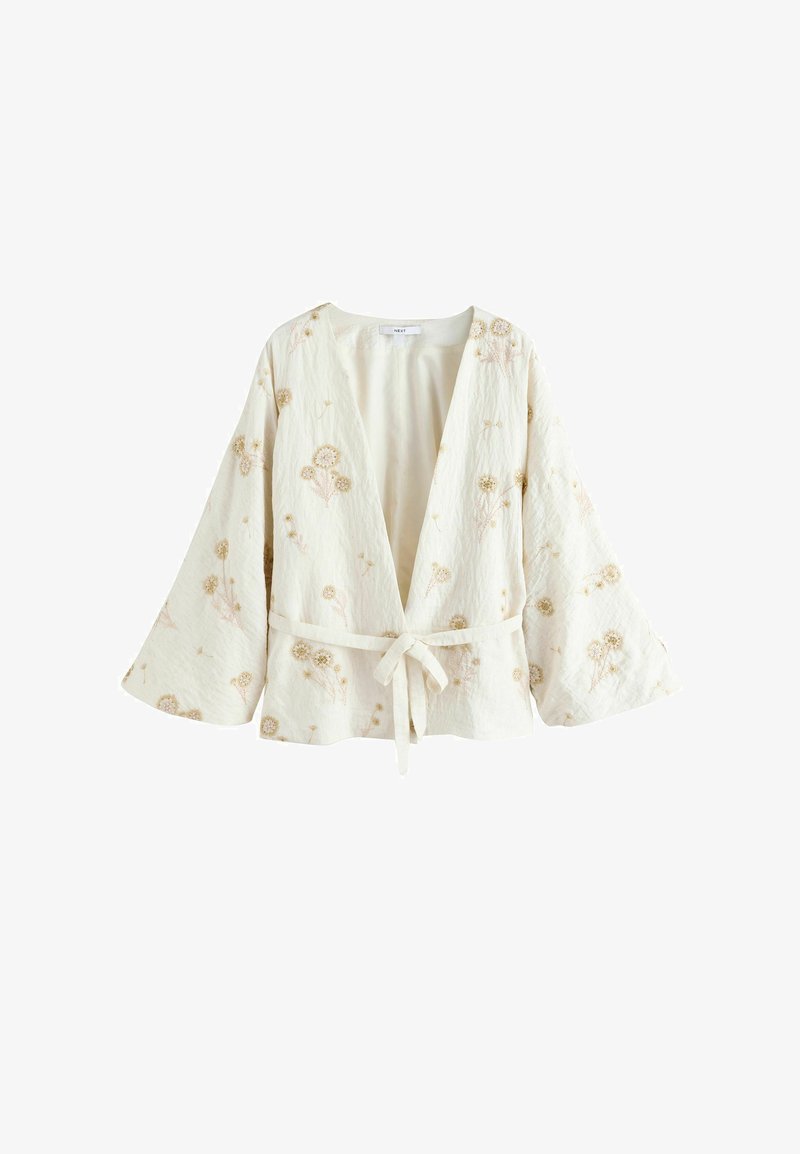 Veste style kimono de couleur crème avec manches larges, broderie florale et ceinture à nouer à l'avant.