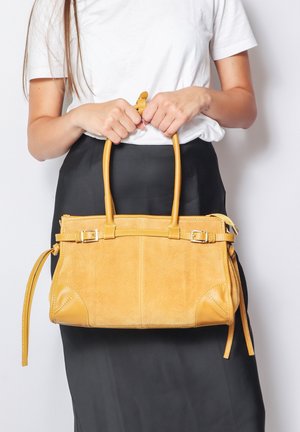 Yellow suede handbag with leather accents, rectangular shape, dual handles, and decorative stitching. Features a removable strap for versatility.