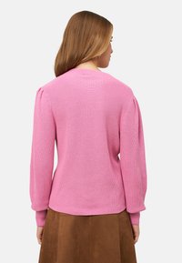 Maglione rosa lavorato a maglia con un design testurizzato, caratterizzato da una scollatura rotonda e maniche lunghe arricciate. Finitura liscia e vestibilità comoda.