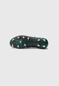 Black and green football shoe sole featuring prominent traction studs and wave-like texture with reflective accents.