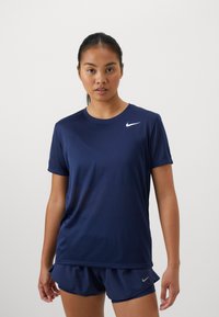 Námořnická modrá sportovní tričko z lehké tkaniny, s krátkými rukávy a kulatým výstřihem; obsahuje malé bílé logo Nike.
