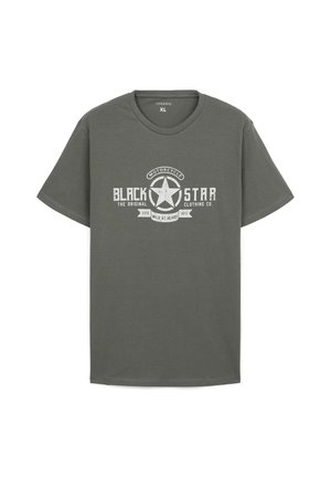 T-shirt in cotone verde oliva con maniche corte, caratterizzato da un design grafico bianco di una stella e la scritta "BLACK STAR" in stile vintage.
