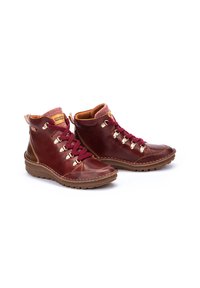 Bottes en cuir marron à la cheville avec des lacets bordeaux, bout de chaussure texturé et œillets en métal. Elles présentent un col rembourré beige et une semelle en caoutchouc.
