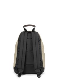 Černý a béžový batoh s polstrovanými popruhy, horním uchytem a hladkým povrchem. Základními rysy jsou minimalistický design a boční kapsy pro uložení.