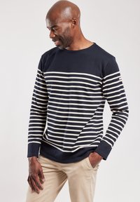 Marineblå langærmet skjorte med cremefarvede vandrette striber, rund halsudskæring og tætsiddende manchetter. Blødt bomuldsblandingstof, afslappet design.