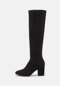 Bottes noires montant jusqu'au genou en daim souple, avec un bout pointu et un talon carré. Le design présente une surface lisse avec des accents minimaux.