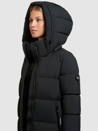 Veste matelassée noire avec une grande capuche, présentant un design matelassé, une fermeture éclair à l'avant et des poches latérales. Texture lisse avec des détails de la marque.