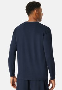 Marineblaues Langarm-Sweatshirt, weiche Baumwollmischung, Rundhalsausschnitt, gerader Saum, gerippte Bündchen, glatte Textur, geeignet für die Freizeit.