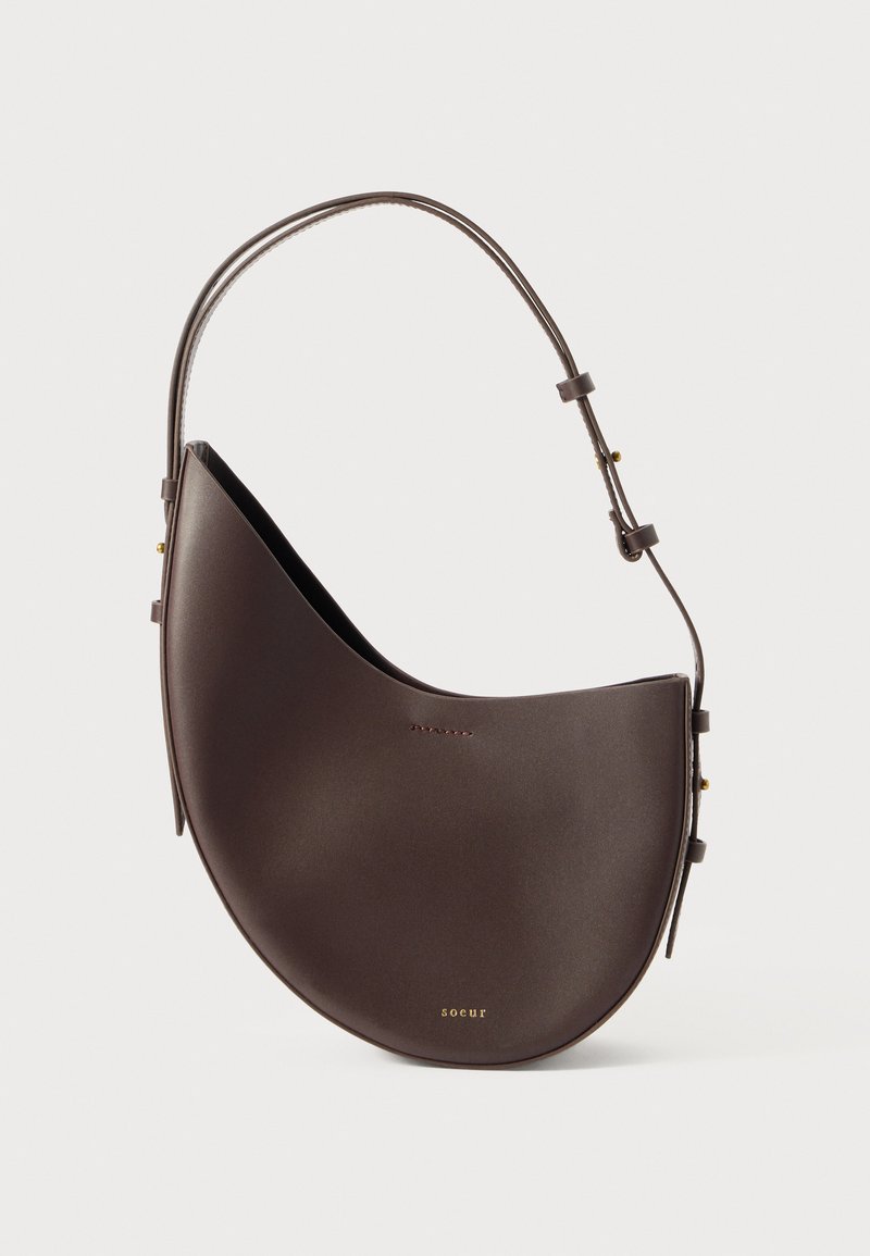 Geantă de umăr din piele maro, cu un design curbat, curea reglabilă și accente din metal auriu. Textură netedă cu branding minimal.