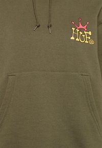 Felpa olivastro con tasca frontale, cordini e un logo stampato con una corona e "HUF" in accenti gialli e rosa.