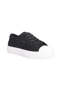 Sneaker nera in tela con una parte superiore strutturata e punta in gomma bianca. Presenta lacci scuri e una suola spessa bianca con scanalature orizzontali.