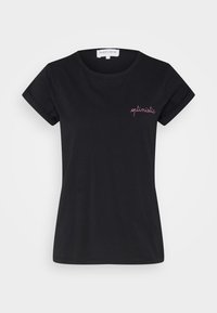 Svart bomullströja med korta, rullade ärmar. Har rosa broderad text "optimistisk" på vänster bröst. Klassisk rund halsringning.