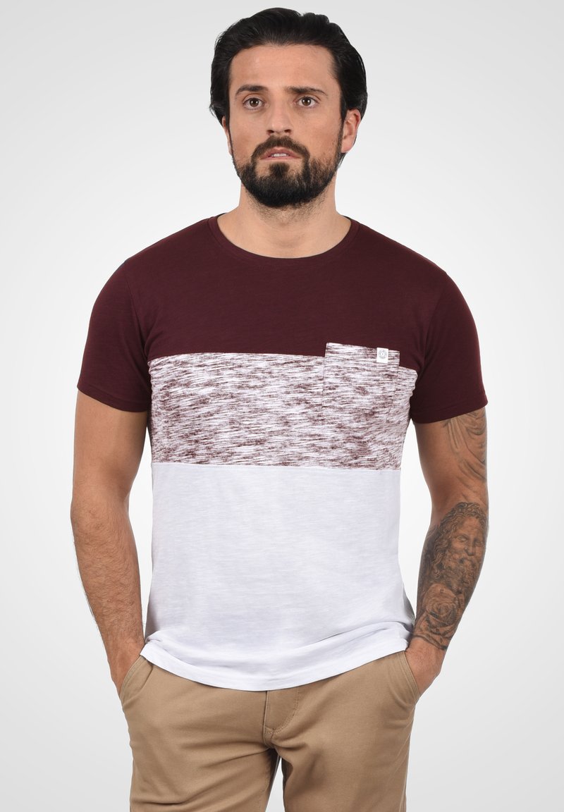 Bordeaux og hvit kortermet t-skjorte med en teksturert horisontal stripe og brystlomme. Glatt bomullsstoff med en enkel rund hals.