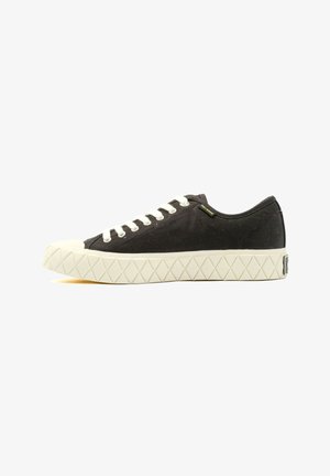 Black canvas sneaker with white laces and a rubber toe cap. Textured rubber sole features a diamond pattern. Minimalist design with logo detail.