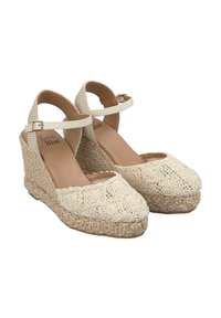 Beige gehaakte espadrille sleehakken met haakdetails, enkelbandje en getextureerde jute basis. Zachte voering en open teen ontwerp.