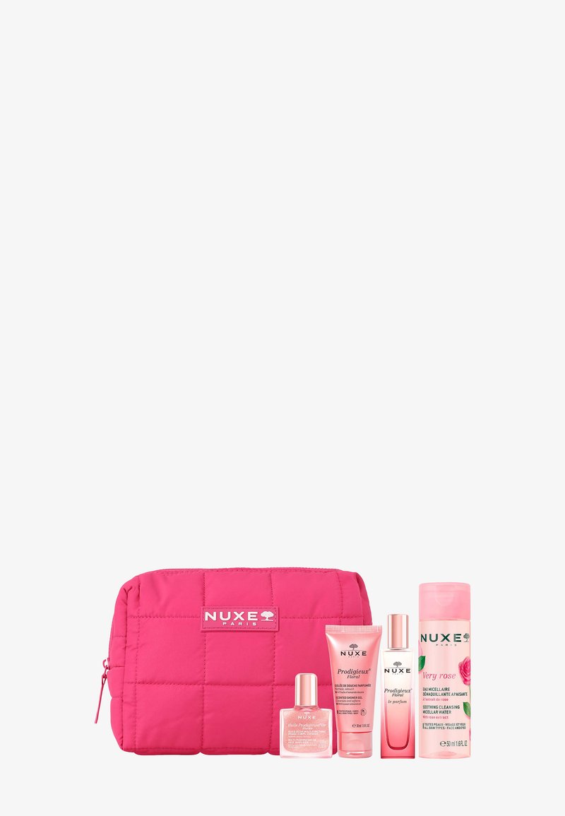 Roze gewatteerde Nuxe cosmetische tas met vier roze huidverzorgingsproducten waaronder douchegel, parfum en micellair reinigingswater.
