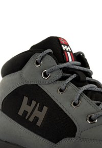 Grijze en zwarte hoge sneaker van canvas en rubber, met een opvallend HH-logo en metalen oogjes met grijze veters.