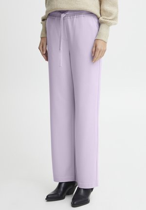 Paarse op maat gemaakte broek met een elastische tailleband en trekkoord, met rechte pijpen en een zachte textuur, gecombineerd met zwarte haklaarzen.
