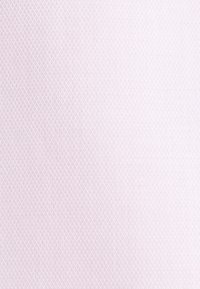 Tissu rose clair avec un motif géométrique texturé composé de petits losanges répétitifs.