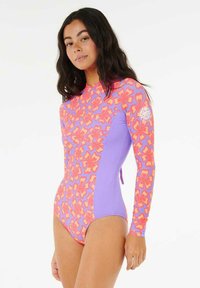 Bañador de manga larga con un patrón floral en tonos rosas y naranjas en un lado, que contrasta con el lavanda sólido en el otro. Fabricado en tejido elástico.