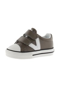 Kinderbruine sneaker met witte rubberen neus, twee klittenbandsluitingen en witte zigzagzijkant.