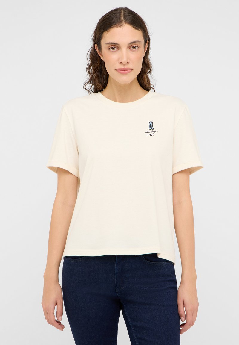 Kremowa, krótki rękaw t-shirt uszyty z miękkiej bawełny, z małym graficznym wzorem na lewej części klatki piersiowej.