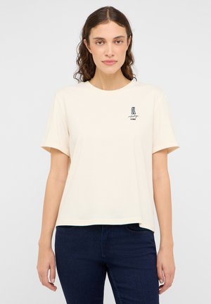 Cream-colored, short-sleeve t-shirt made of soft cotton, featuring a small graphic design on the left chest area.