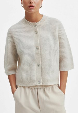 Beige ribbed cardigan with a round neckline, short sleeves, and five button closure. Soft texture and slightly cropped design.