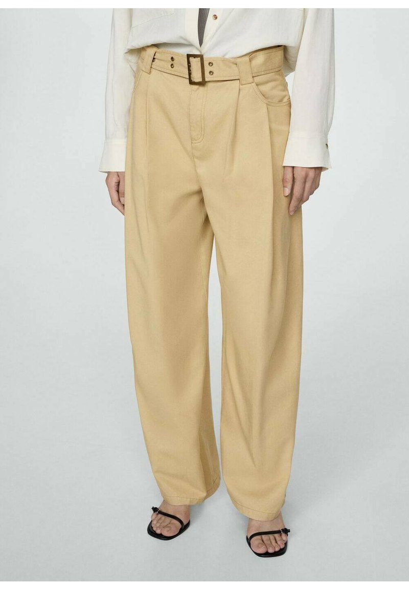 Beige wijde broek met een hoge taille, voorzien van een riem met een rechthoekige gesp en geplooide details. Glad stofgevoel.