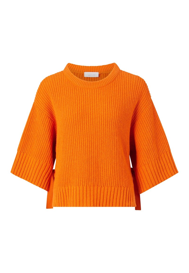 Pull en maille orange vif à manches courtes avec une texture côtelée, des manches larges et un col rond. Présente une coupe droite et des fentes latérales.
